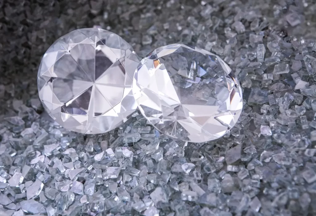 two-diamonds-sitting-on-top-of-a-pile-of-crushed-glass